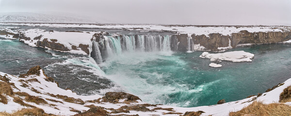 Godafoss waterfall cascading on a snowy winter day in iceland