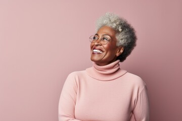 Fototapeta premium Portrait of a blissful afro-american woman in her 60s wearing a classic turtleneck sweater isolated in plain cyclorama studio wall