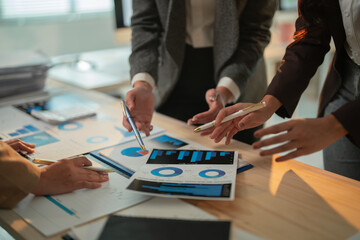 Business team analyzing financial data using charts and graphs, collaborating on investment strategies and market trends during a productive office meeting