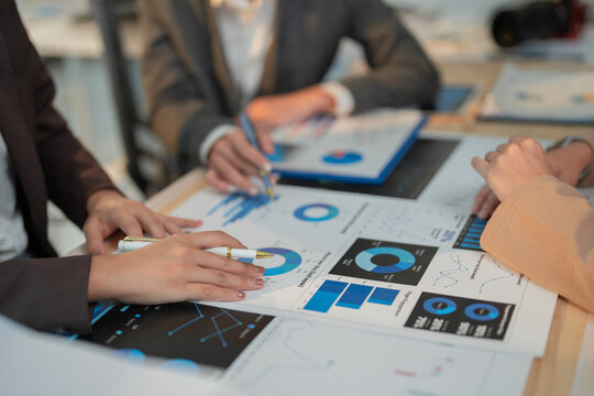 Business team members are studying financial reports, analyzing key performance indicators, and discussing growth strategies during a productive meeting