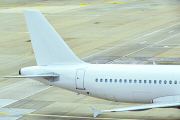 Tail fin and fuselage of an unmarked holiday jet. No people.