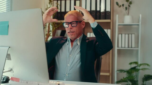 Office worker is getting more and more stressed while working at his desk. He can't believe what is happening on his computer screen