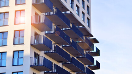 Modern high-rise apartment building  in white, stand tall against a blue sky, exemplifying...