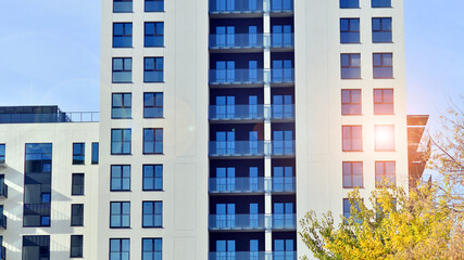 Modern high-rise apartment building  in white, stand tall against a blue sky, exemplifying...