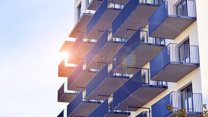 Modern high-rise apartment building  in white, stand tall against a blue sky, exemplifying...