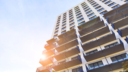 Modern high-rise apartment building  in white, stand tall against a blue sky, exemplifying...
