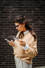 Young caucasian woman using credit card to buy online on her phone	
