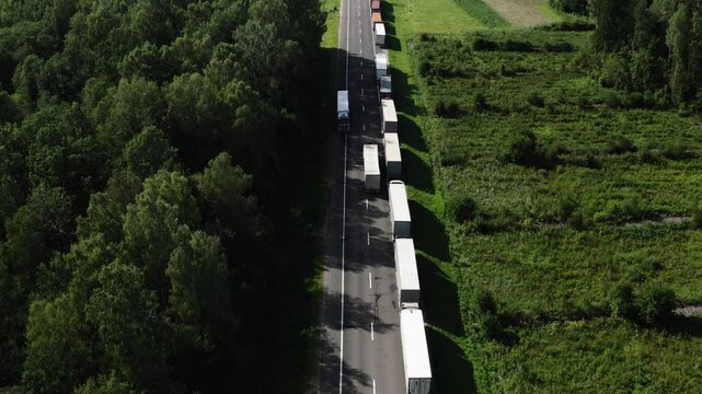 Aerial view: Big queue of trucks. Trucks wait in line for border crossing control. Top view.