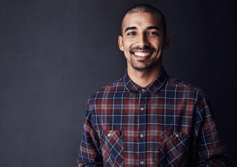 Fototapeta premium Happy, portrait and man in studio mockup with confidence, ambition and creative startup opportunity. Entrepreneur, designer or small business owner on dark background space with pride for development