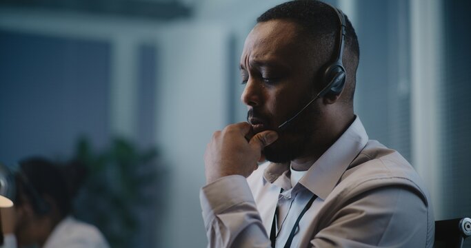 Psychological hotline call center: Close up of African American crisis helpline counselor in headset talking to person during online call, providing mental health support. Suicide prevention service.
