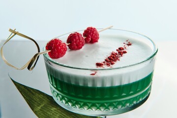Green Cocktail with Foam and Fresh Raspberry Garnish