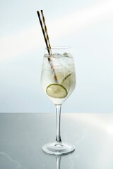 Elegant Clear Beverage with Lime and Pair of Straws
