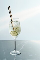 Elegant Clear Beverage with Lime and Pair of Straws