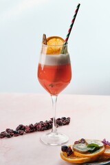 Refreshing Red Cocktail Garnished with Ice and Dried Fruit Chips