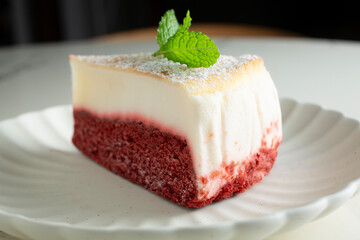 A closeup view of a slice of red velvet cheesecake.