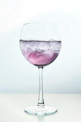 Lilac-Colored Cocktail with Ice Cubes on White Backdrop