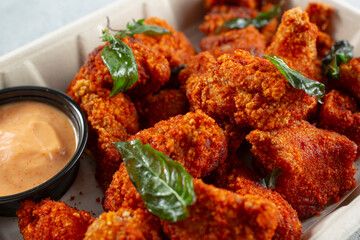 A closeup view of a bowl of spicy popcorn chicken.
