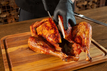 A view of a chef cutting through a roasted turkey.