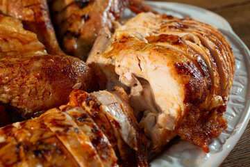 A view of a platter of roasted turkey pieces, featuring sliced breast.