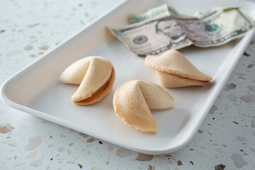 A view of a tray of some fortune cookies and cash.