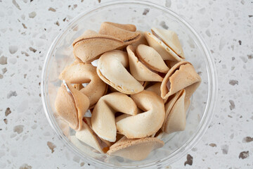 A top down view of a container full of fortune cookies.