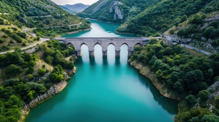 The lake water is blue-green, surrounded by green mountains and forests on both sides of the river, with an ancient stone arch bridge across it