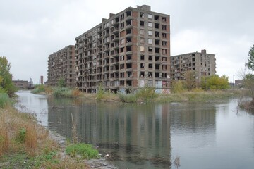 Fototapeta premium Abandoned apartment building reflected in a waterway