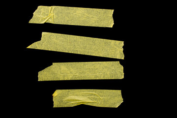 Pieces of masking tape on a black background.