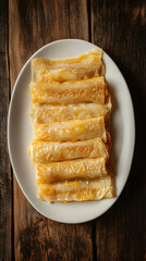 Top view of golden pancakes with a crispy crust, resting on a white plate on an old rustic wooden table
