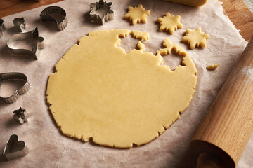 Cutting out star shapes from rolled out dough to prepare traditional Linzer Christmas cookies