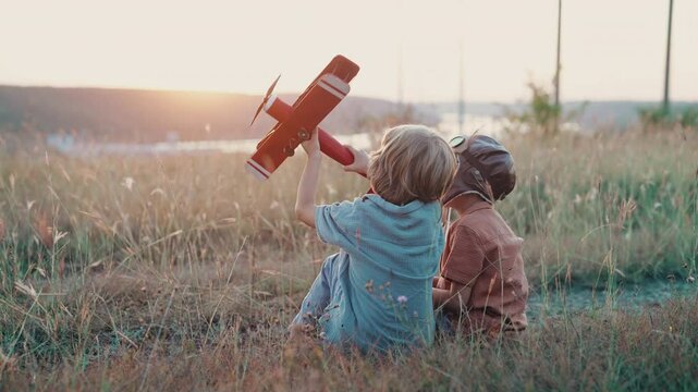 Smiling interested friends brothers, cute boys plays, talks about aviation with handmade wooden vintage plane toy, discovering future pilot profession interests, dreamers kids flying, traveling
