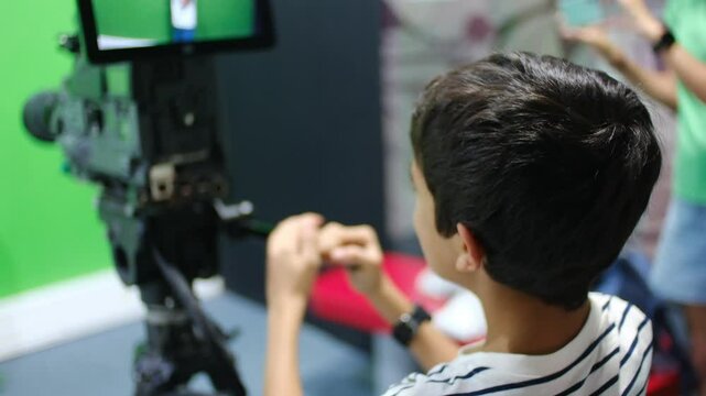 oy learns to use video camera. Filmmaking, education, technology, green screen, studio, learning, childhood.