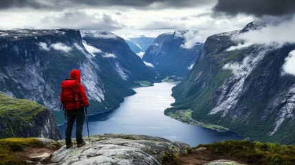 Fototapeta premium Hiker Admires Majestic Fjord Valley Landscape in Norway A Solitary Figure Gazing at the Dramatic Cliffs and Winding Waterway