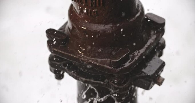 Close-up on a pipe fixture surrounded by splashing and sloshing water. Slow motion