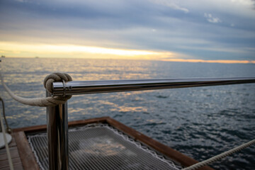 Maritime Stimmung im Sonnenuntergang mit Blick auf ein typisches Bootsgeländer und das Meer im...