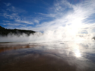 Textures and colors in the Grand Prismatic Springs of Yellowstone National Park with steam rising from the hot boiling waters That flow into the Riverhole river nearby
