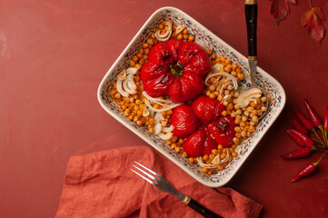 Delicious vegan plate of roasted bell pepper and chickpeas on vibrant red background