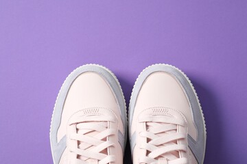 Pair of stylish sneakers on a colored background