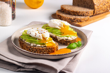 Two avocado open sandwiches with egg. Keto and diet concept. Healthy toast food for breakfast.