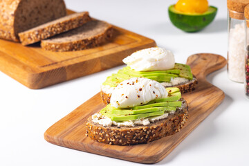 Two avocado open sandwiches with egg. Keto and diet concept. Healthy toast food for breakfast.