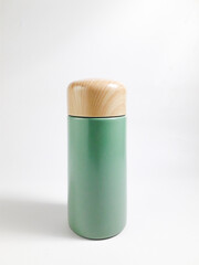Sage green stainless vacuum tumbler with wood-patterned plastic lid, able to keep hot and cold for longer with a capacity of 150ml. Suitable for traveling or working.