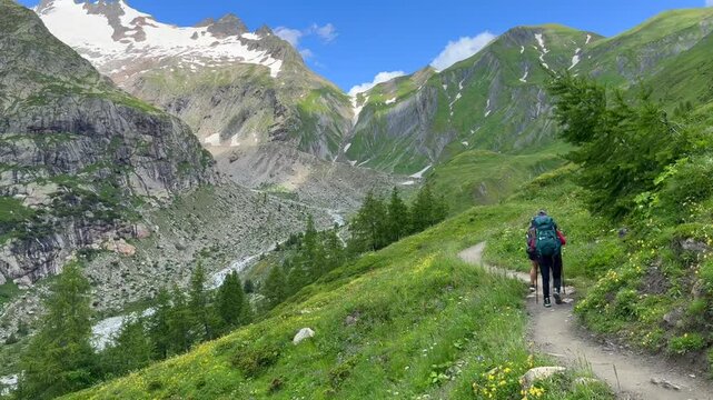 a pair of people hiking in the ALPS mountains - following the TMB (Tour du Mont Blanc) trail