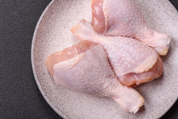 Raw chicken legs with salt, spices and herbs