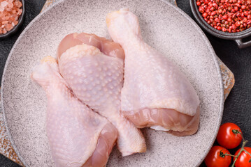 Raw chicken legs with salt, spices and herbs