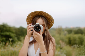 Fototapeta na wymiar A Young Woman Enthusiastically Capturing the Beauty of Nature with a Camera in a Stunning Landscape