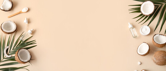 Bottles of coconut cosmetic oil and jar of cream with palm leaves on beige background