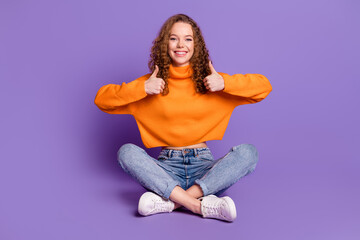 Full size photo of nice young girl sit floor thumb up wear pullover isolated on violet color...