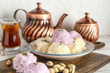 Plate with tasty Turkish Pismaniye and pistachios on table