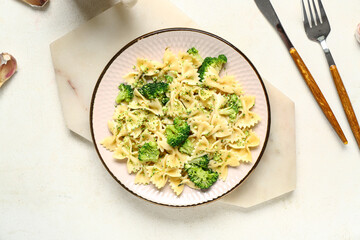 Plate of tasty pasta with broccoli on white background