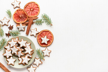 Composition with delicious stars shaped Christmas cookies, spices, orange dried pieces and fir tree branches on light background